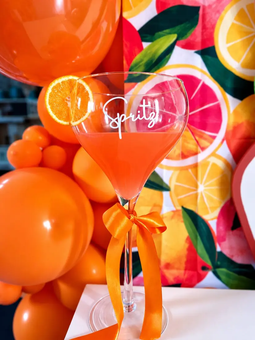détail de décoration évènementielle par ML Events — verre à cocktail Spritz sur fond agrumes